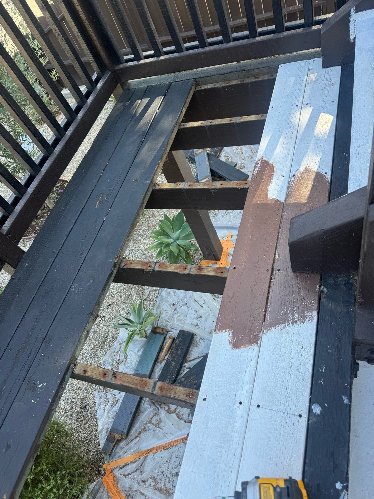 Deck boards removed down to the joists during a repair, with damaged planks pulled out