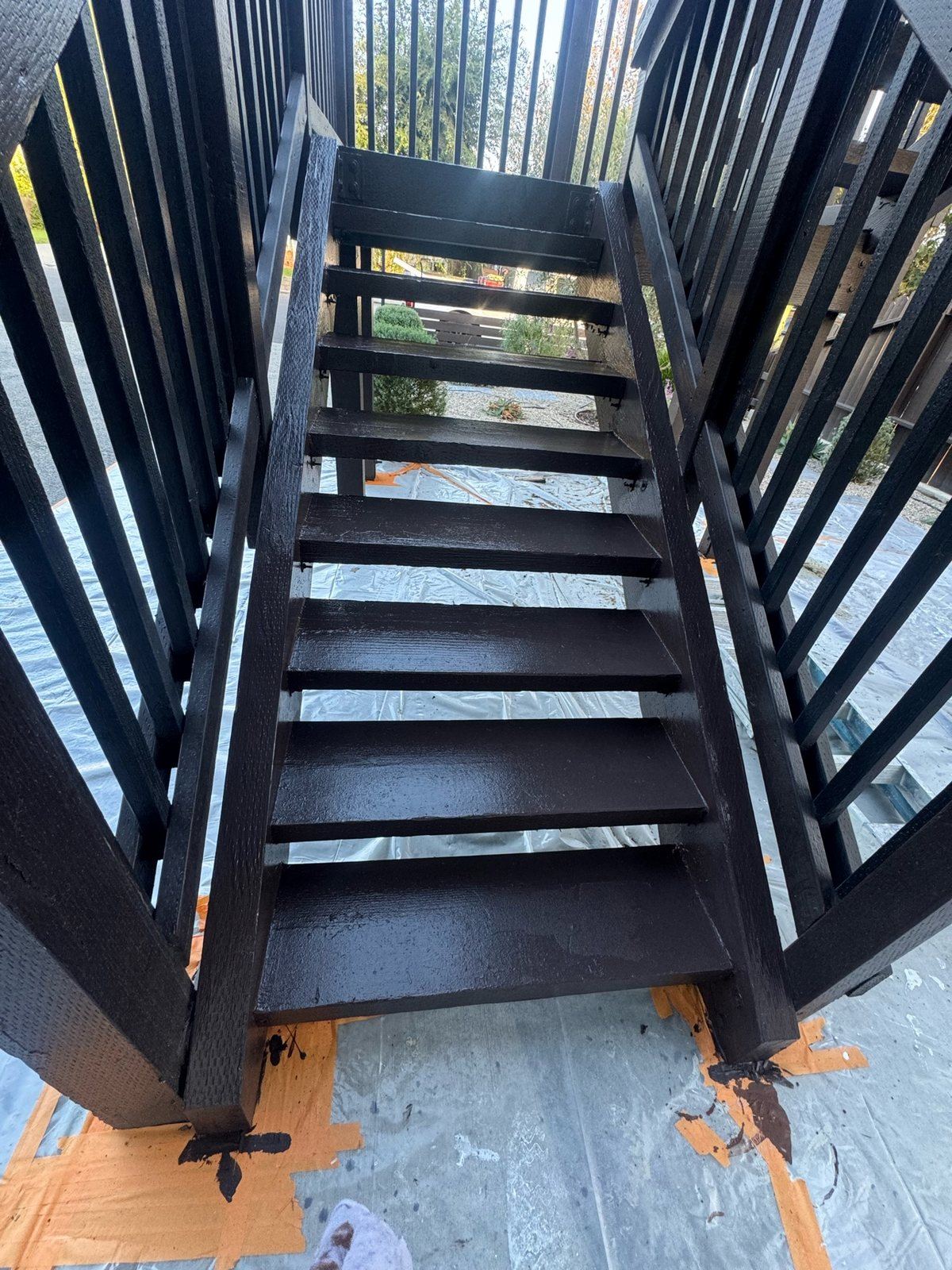 Exterior wood staircase finished in dark brown after tread replacement