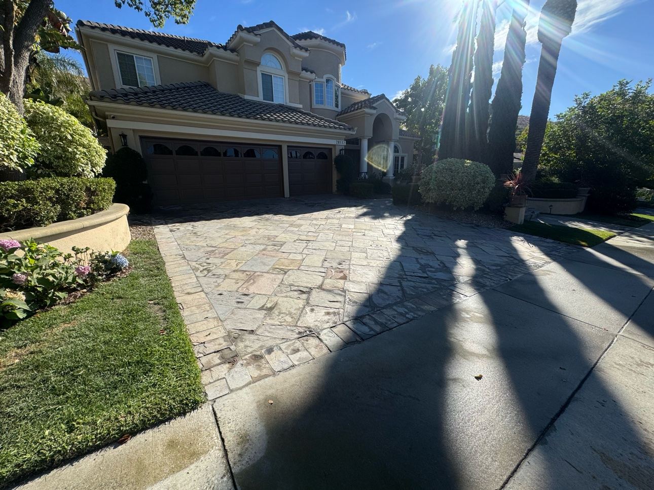 Wide view of a home with its slate tile driveway repaired and cleaned