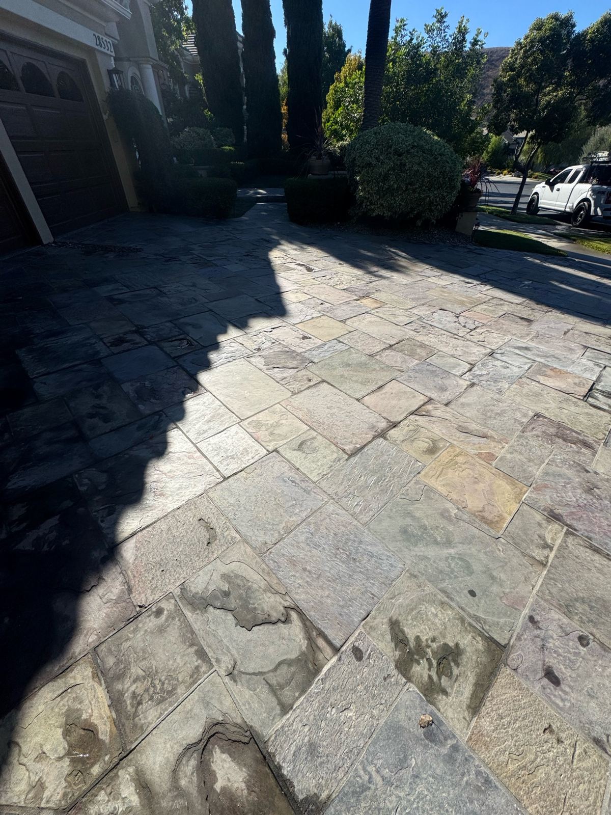 Repaired slate tile driveway seen from the garage side in sunlight