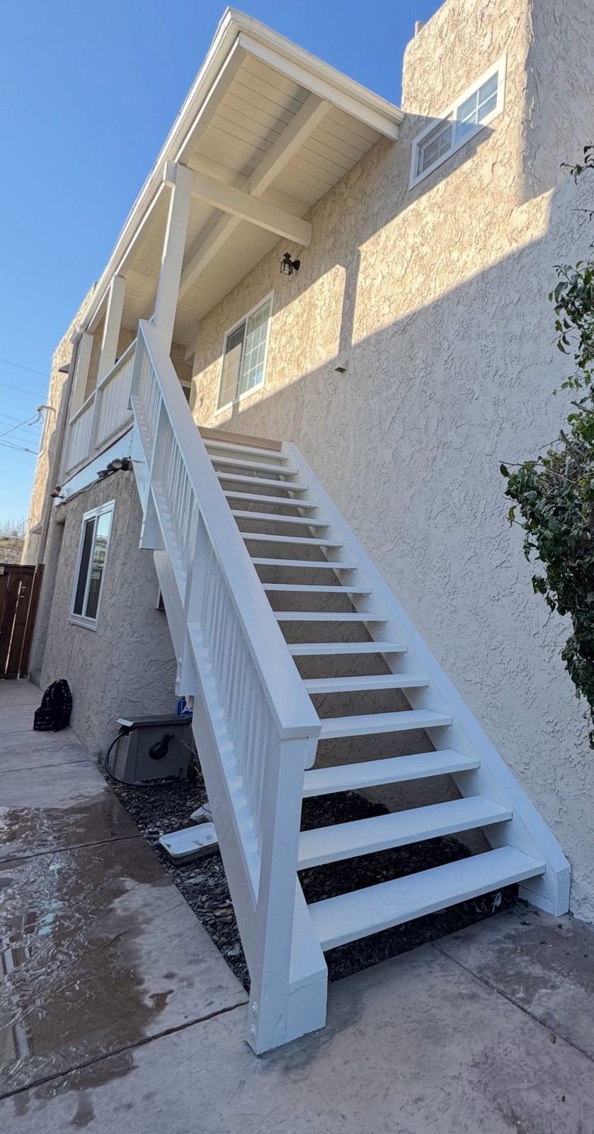 Completed white exterior staircase replacement against a stucco home