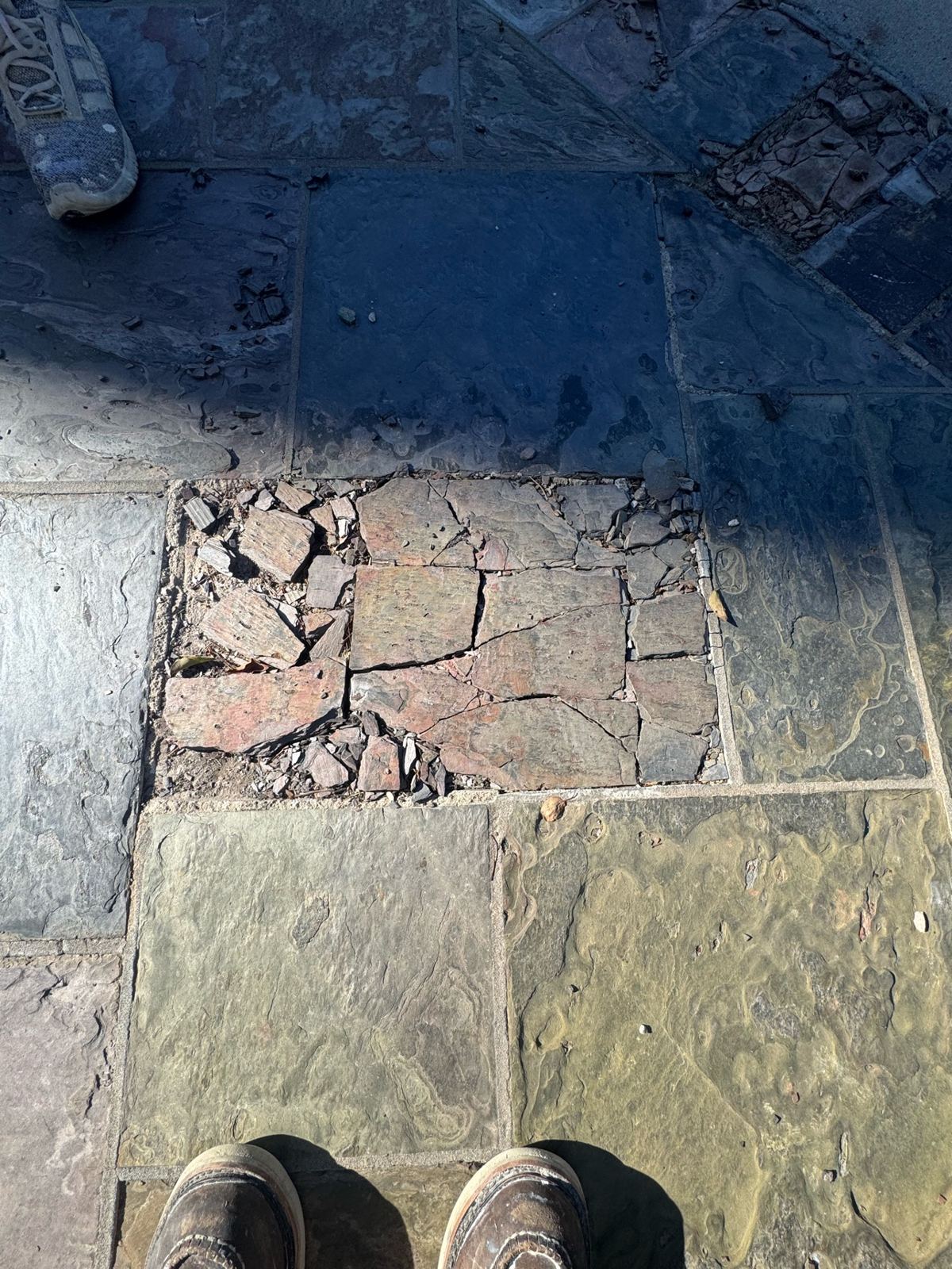 Before photo of a slate driveway tile shattered into cracked pieces